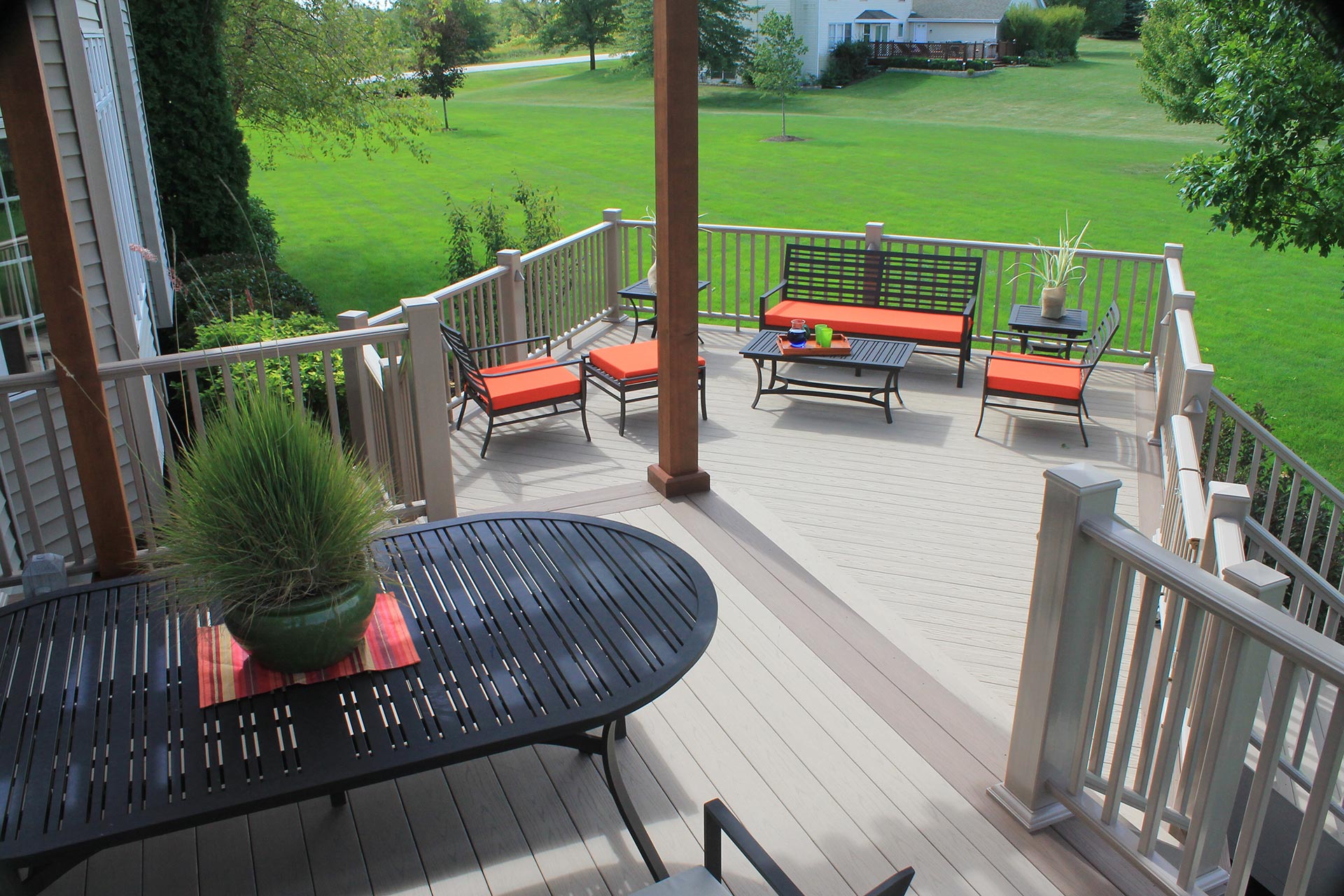 top view of a second story wooden deck with outdoor seating and tables